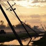 
              FILE - Downed power lines slump over a road in the aftermath of Hurricane Ida, Friday, Sept. 3, 2021, in Reserve, La. Weather disasters fueled by climate change now roll across the U.S. year-round, battering the nation's aging electric grid. (AP Photo/Matt Slocum, File)
            