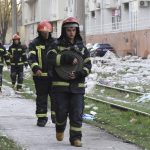 
              Firefighters walk past an apartment building damaged by Russian shelling in Odesa, Ukraine, Saturday, April 23, 2022. Ukrainian officials reported that Russia fired at least six cruise missiles at the Black Sea port city of Odesa, killing five people. (AP Photo/Max Pshybyshevsky)
            