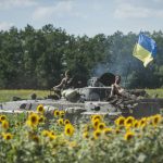 
              FILE - Ukrainian troops ride on an APC with a Ukrainian flag, in a field with sunflowers in Kryva Luka, eastern Ukraine, on July 5, 2014. Prices for food commodities like grains and vegetable oils reached their highest levels ever last month because of Russia's war in Ukraine and the “massive supply disruptions” it is causing, the United Nations said Friday, April 8, 2022.  (AP Photo/Evgeniy Maloletka)
            