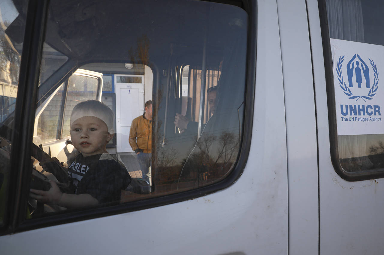 A young child sits behind the wheel of a UNHCR minivan after arriving from Ukraine to Moldova at th...