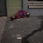 
              An injured woman lies on the sidewalk during a Russian bombardment in Kharkiv, Ukraine, Sunday, April 17, 2022. (AP Photo/Felipe Dana)
            