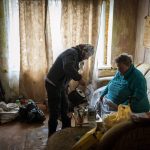 
              Lyubov Lomachuk, 69, serves tea to her neighbour Valentyna Volynets, 59, after boiling water for her on a makeshift fire in a public garden near their building in Bucha, on the outskirts of Kyiv, Monday, April 18, 2022. Citizens of Bucha are still without electricity, water and gas after more than 43 days since the Russian invasion began. (AP Photo/Emilio Morenatti)
            