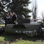 
              Ukrainian servicemen stand next to a fragment of a Tochka-U missile with a writing in Russian "For children" , on a grass after Russian shelling at the railway station in Kramatorsk, Ukraine, Friday, April 8, 2022. (AP Photo/Andriy Andriyenko)
            