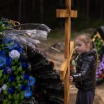 
              Darya Piven, 33, looks as her daughter Zlata, 6, as she visits the graves of her parents Nadiya Myakushko, 69, and Volodymyr Cherednichenko, 75, who were killed by Russian army in Irpin on March 24, in Irpin, on the outskirts of Kyiv, Monday, April 25, 2022. (AP Photo/Emilio Morenatti)
            