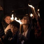 
              Christian pilgrims hold candles as they gather during the ceremony of the Holy Fire at Church of the Holy Sepulchre, where many Christians believe Jesus was crucified, buried and rose from the dead, in the Old City of Jerusalem dead, Saturday, April 23, 2022. (AP Photo/Maya Alleruzzo)
            