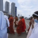 
              Sri Lankan Catholic nuns and Buddhist monks arrive  to attend an alms giving in memory of victims of the 2019 Easter Sunday Attacks in Colombo, Sri Lanka, Thursday, April 21, 2022. (AP Photo/Eranga Jayawardena)
            