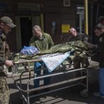 
              Ukrainian military medics transport an injured Ukrainian serviceman in Donetsk region, eastern Ukraine, Sunday, April 24, 2022. (AP Photo/Evgeniy Maloletka)
            