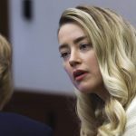 
              Actor Amber Heard speaks to her attorney during a hearing in the courtroom at the Fairfax County Circuit Court in Fairfax, Va., Wednesday, April 20, 2022. Actor Johnny Depp sued his ex-wife Amber Heard for libel in Fairfax County Circuit Court after she wrote an op-ed piece in The Washington Post in 2018 referring to herself as a "public figure representing domestic abuse." (Evelyn Hockstein/Pool via AP)
            