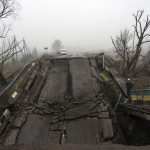 
              A motorcyclist looks at a bridge destroyed by the Russian army when it retreated from villages on the outskirts of Kyiv, Ukraine, Friday, April 1, 2022. (AP Photo/Rodrigo Abd)
            