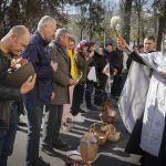 
              A men holds military helmet with traditional cakes and painted eggs as Ukrainian priest blesses believers during Easter celebration in Kyiv, Ukraine, Sunday, Apr. 24, 2022. (AP Photo/Efrem Lukatsky)
            