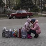 
              A mother hugs her daughter as they wait for a bus to flee from Sloviansk city, in Donetsk district, to travel to Rivne , western Ukraine, on Saturday, April 16, 2022. (AP Photo/Petros Giannakouris)
            