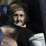 
              An elderly woman sits in a bus as civillians are evacuated, in Kramatorsk, Ukraine, Saturday, April 9, 2022. (AP Photo/Andriy Andriyenko)
            