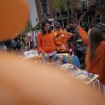 
              Orange-clad children sell books on a "free market" during King's Day celebrations in Amsterdam, Netherlands, Wednesday, April 27, 2022. After two years of celebrations muted by coronavirus lockdowns, the Netherlands marked the 55th anniversary of King Willem-Alexander of the House of Orange with street parties, music festivals and a national poll showing trust in the monarch ebbing away. (AP Photo/Peter Dejong)
            