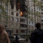 
              People watch as a residential building burns following a Russian bombardment in Kharkiv, Ukraine, Monday, April 25, 2022. (AP Photo/Felipe Dana)
            