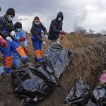 
              FILE - Dead bodies are placed into a mass grave on the outskirts of Mariupol, Ukraine, Wednesday, March 9, 2022 as people cannot bury their dead because of the heavy shelling by Russian forces. (AP Photo/Evgeniy Maloletka, File)
            