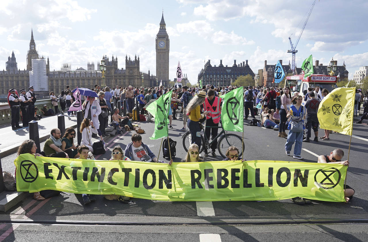 Demonstrators take part in an Extinction Rebellion protest on Westminster Bridge in London, Friday,...