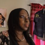 
              ShiVanda Peebles poses for a portrait as a photo of her with her husband, Sherman, hangs on the wall next to his sheriff's uniform at their home in Columbus, Ga., Tuesday, March 8, 2022. In late September, as Sherman Peebles lay in the hospital, the U.S. toll topped 675,000, surpassing the number of Americans killed by the Spanish flu pandemic a century ago. He died the following day. (AP Photo/David Goldman)
            