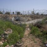 
              An Israeli soldier guards an opening in Israel's West Bank separation barrier that was reinforced with barbed wire to prevent Palestinians from crossing into Israel, in the West Bank village of Nilin, west of Ramallah, Sunday, April 10, 2022. Israel has stepped up its surveillance of the barrier following a pair of attacks in recent weeks carried out by Palestinians who had entered Israel without a permit. (AP Photo/Nasser Nasser)
            