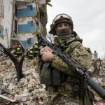 
              A Ukrainian soldier stands against the background of an apartment house ruined in the Russian shelling in Borodyanka, Ukraine, Wednesday, Apr. 6, 2022. (AP Photo/Efrem Lukatsky)
            