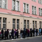 
              People from the Ukraine most of them refugees fleeing the war, wait in front of the consular department of the Ukrainian embassy in Berlin, Germany, Friday, April 1, 2022. (AP Photo/Markus Schreiber)
            