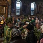 
              A priest sprinkles holy water on the faithful during an Orthodox service celebrating Palm Sunday, in the Holy Trinity Cathedral, in Kramatorsk, Ukraine, Sunday, April 17, 2022. (AP Photo/Petros Giannakouris)
            