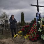 
              Galyna Bondar, mourns next to the grave of her son Oleksandr, 32, after burying him at the cemetery in Bucha, on the outskirts of Kyiv, Ukraine on Saturday, April 16, 2022. Oleksandr, who joined the territorial Ukrainian defence as a co-ordinator was killed by a gunshot by the Russian Army. (AP Photo/Rodrigo Abd)
            