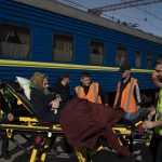 
              An elderly woman is carried on a stretcher before boarding a train at a train station in Pokrovsk, Ukraine, Monday, April 25, 2022, to flee the war in Severodonetsk and nearby towns. Russia unleashed a string of attacks against Ukrainian rail and fuel installations Monday, striking crucial infrastructure far from the front line of its eastern offensive. (AP Photo/Leo Correa)
            