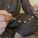 
              Wolayat Khan Samadzoi prays using beads made in the colors of the flag of his native Afghanistan in his new apartment in Las Cruces, N.M., Saturday, April 2, 2022. Samadzoi and thousands of other Afghans evacuated to the United States as the Taliban regained power last summer are celebrating their first Muslim holy month of Ramadan here – grateful to be safe, but agonizing over their families back home under the repressive Taliban regime. (AP Photo/Giovanna Dell'Orto)
            