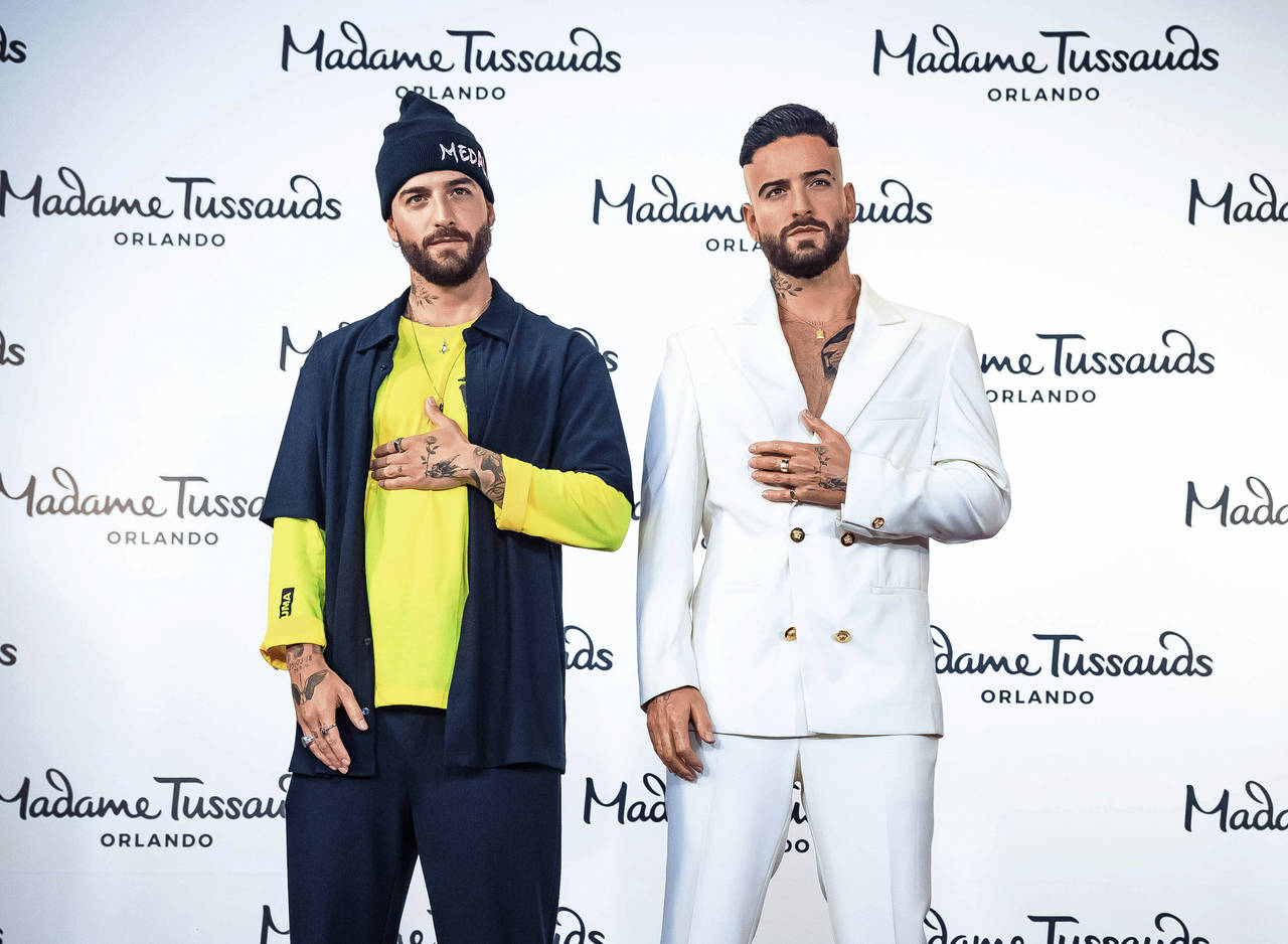 This image released by Madam Tussauds Orlando shows Colombian singer Maluma, left, next to his wax ...
