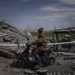 
              A man drives a scooter next to a bridge destroyed by shelling near Orihiv, Ukraine, Thursday, May 5, 2022. (AP Photo/Evgeniy Maloletka)
            