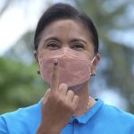 
              CORRECTS PLACE - Presidential candidate and incumbent Vice President Leni Robredo shows the ink on her finger to mark that she has finished voting at a school used as a polling center in Camarines Sur, eastern Philippines on Monday, May 9, 2022. Filipinos were voting for a new president Monday, with the son of an ousted dictator and a champion of reforms and human rights as top contenders in a tenuous moment in a deeply divided Asian democracy. (AP Photo/Zalrian Sayat)
            