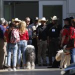 Police and members of the Brooke Army Medical Center Therapy Dogs unit gather outside of the Civic Center in Uvalde, Texas, Wednesday, May 25, 2022. The 18-year-old gunman who slaughtered 19 children and two teachers at a Texas elementary school barricaded himself inside a single classroom and "began shooting anyone that was in his way," authorities said Wednesday in detailing the latest mass killing to rock the U.S. (AP Photo/Dario Lopez-Mills)