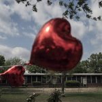 
              A heart-shaped balloon flies, decorating a memorial site outside Robb Elementary School in Uvalde, Texas, on Monday, May 30, 2022. In a town as small as Uvalde, even those who didn't lose their own child lost someone. Some say now that closeness is both their blessing and their curse: they can lean on each other to grieve. But every single one of them is grieving. (AP Photo/Wong Maye-E)
            