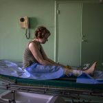 
              Olena Viter, 45, waits outside the operating theatre before a surgery, at a public hospital in Kyiv, Ukraine, Tuesday, May 10, 2022. Olena lost her leg and her 14-year-old son Ivan when bombs rained down on their village Rozvazhiv, in the Kyiv region, on March 14. Four people died, including Ivan, and about 20 were wounded. (AP Photo/Emilio Morenatti)
            