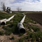 
              Water pipes lie dormant on Don Schneider's property Friday, April 29, 2022, in Ovid, Colo. He pumps water from a shallow aquifer for irrigation, and uses supply from the South Platte River to replenish the wells. (AP Photo/Brittany Peterson)
            