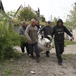 
              Volunteers exhume the bodies of civilians killed by Russian shelling in the village of Stepaky, close to Kharkiv, Ukraine, Wednesday, May 11, 2022. (AP Photo/Andrii Marienko)
            