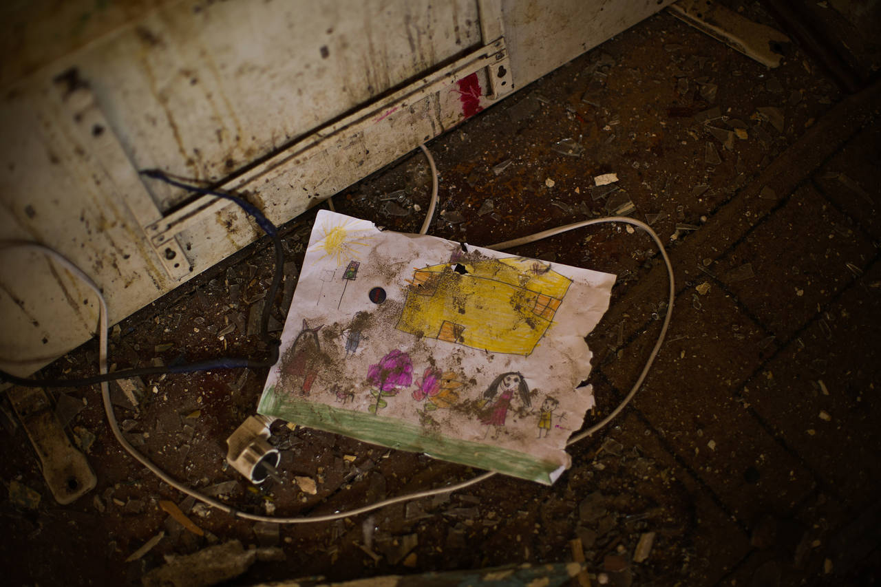 A child's drawing lays on the floor of Iryna Martsyniuk's home, heavily damaged after a Russian bom...
