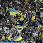 
              Spectators hold Ukraine flags and banners during the soccer match between Borussia Moenchengladbach and Ukraine's national soccer team at Borussia Park, Monchengladbach, Germany, Wednesday May 11, 2022. (Federico Gambarini/dpa via AP)
            