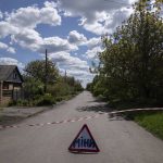 
              A sign that reads "Mines" placed on a road where unexploded devices were found after shelling of Russian forces in Maksymilyanivka, Ukraine, Tuesday, May 10, 2022. (AP Photo/Evgeniy Maloletka)
            