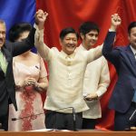 
              President-elect Ferdinand 'Bongbong" Marcos Jr. raises hands with Senate President Vicente Sotto III, left, and House Speaker Lord Allan Velasco during his proclamation at the House of Representatives, Quezon City, Philippines on Wednesday, May 25, 2022. Marcos Jr. was proclaimed the next president of the Philippines by a joint session of Congress Wednesday in an astonishingly huge electoral triumph 36 years after his father was ousted as a brutal dictator by a pro-democracy uprising. (AP Photo/Aaron Favila)
            
