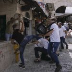 
              Palestinians and Jewish youths clash in Jerusalem's Old City as Israelis mark Jerusalem Day, an Israeli holiday celebrating the capture of the Old City during the 1967 Mideast war. Sunday, May 29, 2022. Israel claims all of Jerusalem as its capital. But Palestinians, who seek east Jerusalem as the capital of a future state, see the march as a provocation. Last year, the parade helped trigger an 11-day war between Israel and Gaza militants. (AP Photo/Ariel Schalit)
            