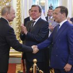 
              FILE - Vladimir Putin shakes hands with Dmitry Medvedev during his inauguration ceremony as new Russia's president in the Grand Kremlin Palace in Moscow, Russia, on May 7, 2018, with former German Chancellor Gerhard Schroeder in centre. Gerhard Schroeder left the German chancellery after a narrow election defeat in 2005 with an ambitious overhaul of the country’s welfare state beginning to kick in and every chance of becoming a respected elder statesman. Fast-forward to last week: German lawmakers agreed to shut down Schroeder’s taxpayer-funded office, the European Parliament called for him to be sanctioned, and his own party set a mid-June hearing on applications to have him expelled. Schroeder’s association with the Russian energy sector turned the 78-year-old into a political pariah in Germany after the invasion of Ukraine. (Alexei Druzhinin, Sputnik, Kremlin Pool Photo via AP)
            