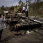 
              Maksym, 3, is photographed with his brother, Dmytro, 16, on top of a destroyed Russian tank, on the outskirts of Kyiv, Ukraine on Sunday, May 8, 2022. (AP Photo/Emilio Morenatti)
            