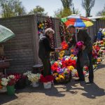 
              A man buys flower at the Kapustyanyy cemetery during the day Ukrainians mark as the day of the dead in Zaporizhzhia, Ukraine, Sunday, May 1, 2022. (AP Photo/Francisco Seco)
            