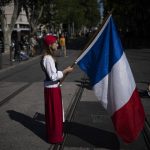 
              A woman dressed up as Marianne, a woman symbol of the French republic since the 1789 revolution, holds a French flag during a May Day demonstration in Marseille, southern France, Sunday, May 1, 2022. May 1 is celebrated as the International Labour Day or May Day across the world. (AP Photo/Daniel Cole)
            