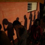 
              The shadows of Haitian migrants are cast on a wall as they wait to receive food at a tourist campground in Sierra Morena, in the Villa Clara province of Cuba, Wednesday, May 25, 2022. A vessel carrying more than 800 Haitians trying to reach the United States wound up instead on the coast of central Cuba, government news media said Wednesday. (AP Photo Ramon Espinosa)
            
