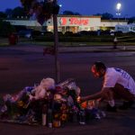 
              A person pays his respects outside the scene of a shooting at a supermarket, in Buffalo, N.Y., Sunday, May 15, 2022. (AP Photo/Matt Rourke)
            