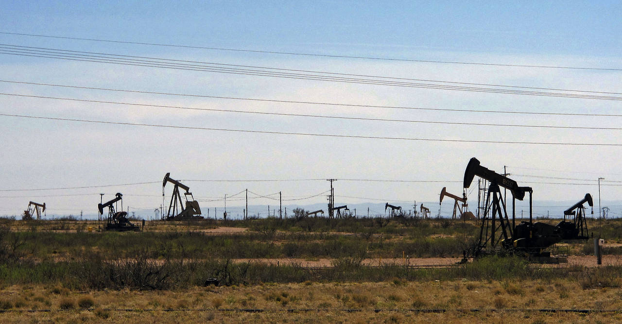 FILE - Oil rigs stand in the Loco Hills field along U.S. Highway 82 in Eddy County, near Artesia, N...