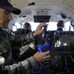 
              Dan Berisford, an engineer with Airborne Snow Observatories, puts on an oxygen mask as he prepares to oversee the inaugural flight above the headwaters of the Colorado River using a 3-D laser mapping device to measure properties of snow from the air Monday, April 18, 2022, in Gunnison, Colo. As climate change disrupts weather patterns, current water forecasting methods are becoming less reliable, but new ways of measuring snow — including the airplane-based 3-D laser mapping system — are emerging across the arid West. (AP Photo/Brittany Peterson)
            