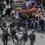 
              Israeli police confront with mourners as they carry the casket of slain Al Jazeera veteran journalist Shireen Abu Akleh during her funeral in east Jerusalem, Friday, May 13, 2022. Abu Akleh, a Palestinian-American reporter who covered the Mideast conflict for more than 25 years, was shot dead Wednesday during an Israeli military raid in the West Bank town of Jenin. (AP Photo/Maya Levin)
            